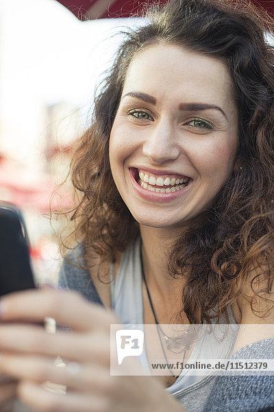 Young woman using smartphone  smiling  portrait