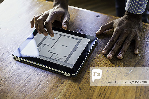 Architekt mit digitalem Tablett zur Ansicht von Plänen
