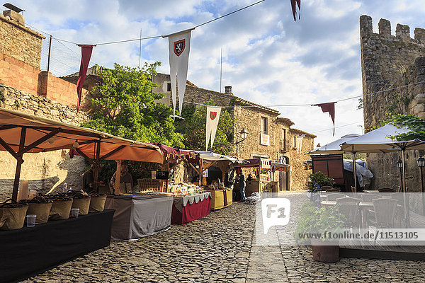 Wunderschönes mittelalterliches Dorf  Markt auf einer Kopfsteinpflasterstraße mit Fahnen  Peratallada  Baix Emporda  Girona  Katalonien  Spanien  Europa