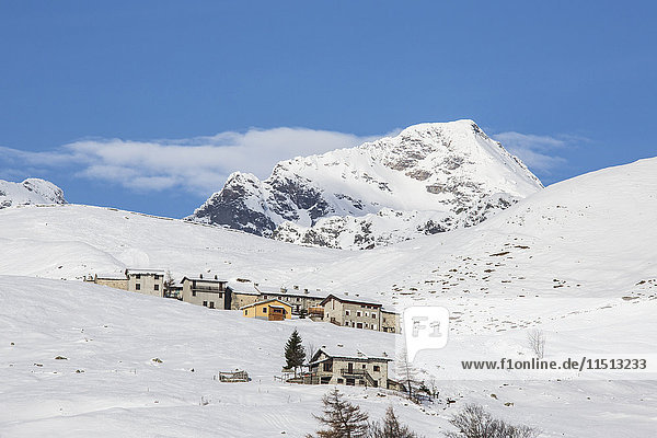 The snowy huts frame Peak Tambo in the background Andossi Spluga Valley Province of Sondrio Valtellina Lombardy Italy Europe
