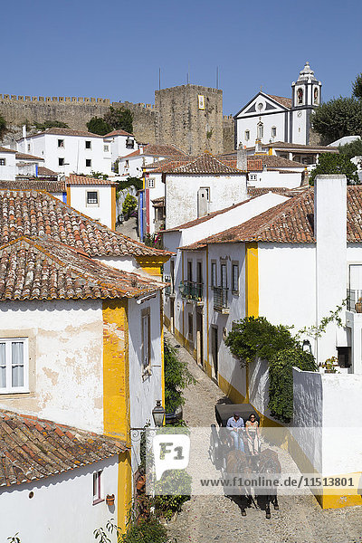 Pferdekutsche und Überblick über die Stadt mit mittelalterlicher Burg im Hintergrund  Obidos  Portugal  Europa