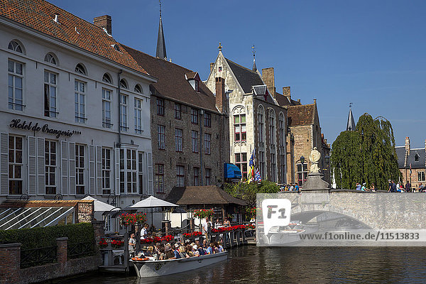 Tourists in boats travel on the Den Dijver canal in summer  Bruges  West Flanders  Belgium  Europe