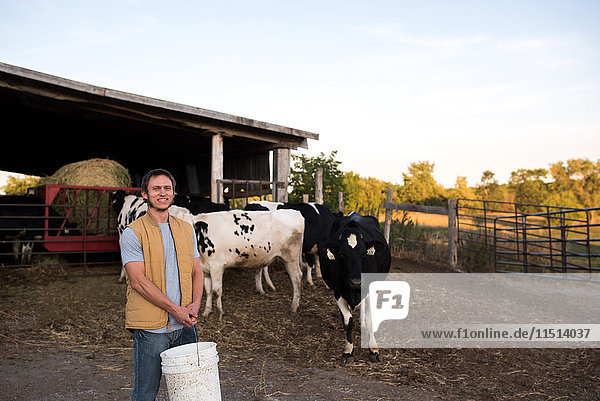 Porträt eines Bauern auf dem Bauernhof  der Tierfutter hält