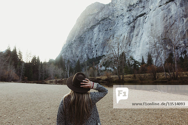 Rückansicht einer Frau mit Hut  die auf einen Berg schaut  Yosemite National Park  Kalifornien  USA