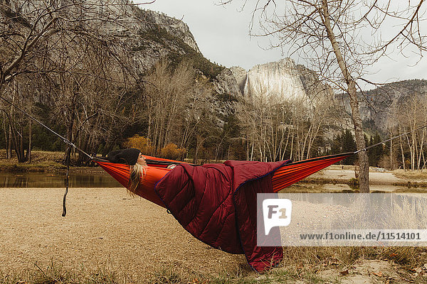In roter Hängematte liegende Frau mit Blick auf die Landschaft  Yosemite National Park  Kalifornien  USA