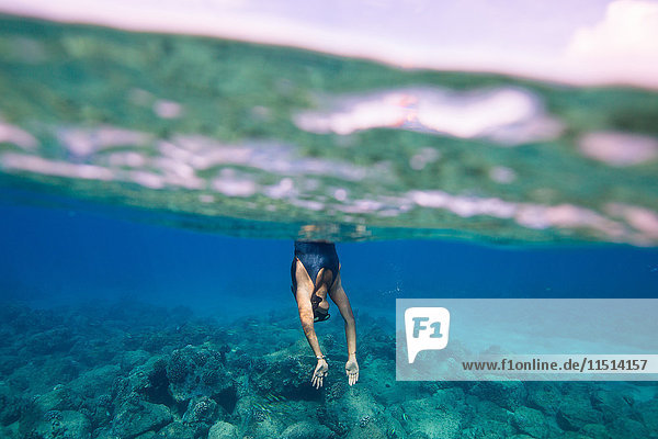 Unterwasseraufnahme einer Frau  die ins Wasser taucht  Oahu  Hawaii  USA