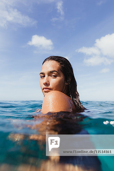 Frau im Meer  die vor der Kamera über die Schulter schaut  Oahu  Hawaii  USA