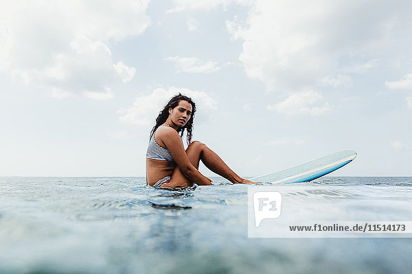 Oberflächenansicht einer Frau auf einem Surfbrett  die in die Kamera schaut  Oahu  Hawaii  USA