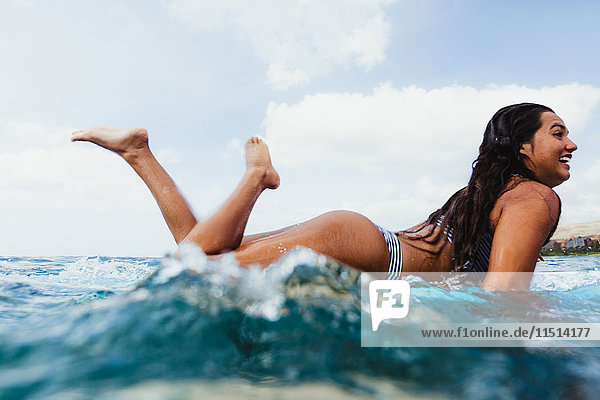 Oberflächenansicht einer auf einem Surfbrett liegenden Frau  Oahu  Hawaii  USA
