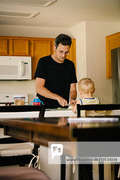 Vater und kleiner Sohn zu Hause  Vater bereitet das Essen vor