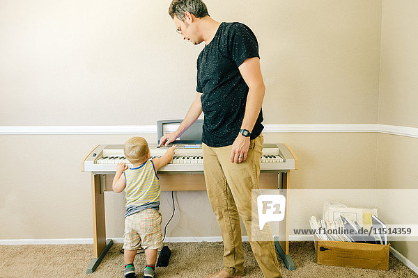 Vater und kleiner Sohn spielen gemeinsam Musiktastatur