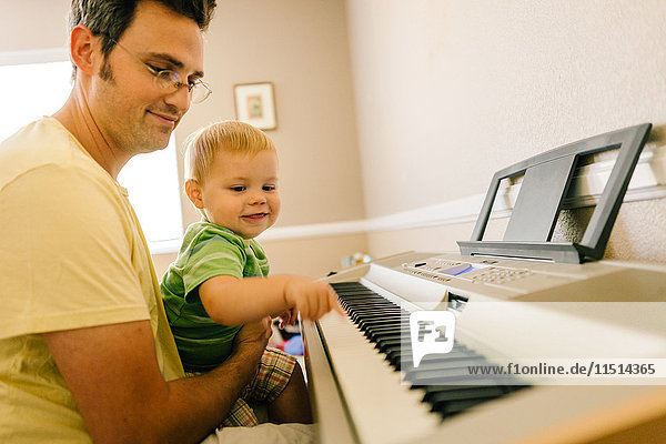 Vater und kleiner Sohn spielen gemeinsam Musiktastatur