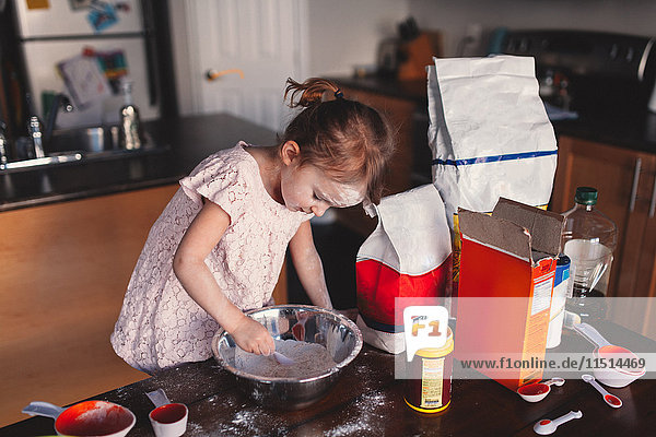 Unordentliches Mädchen in der Küche Rührschüssel mit Mehl