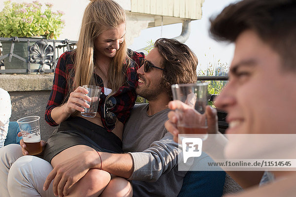 Erwachsene Freunde entspannen bei Drinks auf der Dachterrassenparty