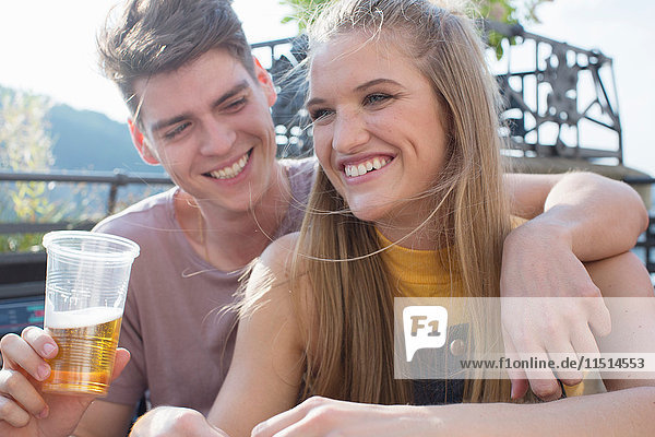 Young couple with drinks at roof terrace party