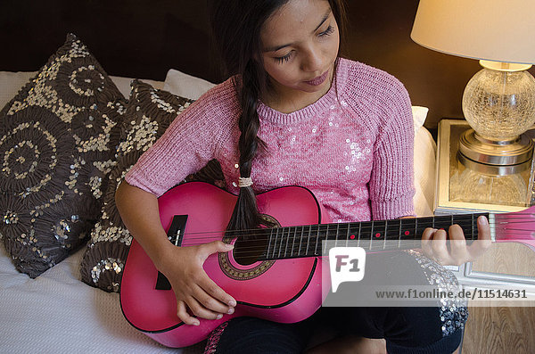Junges Mädchen zu Hause  das Gitarre spielt
