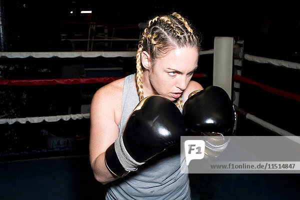 Female boxer poised for sparring in boxing ring