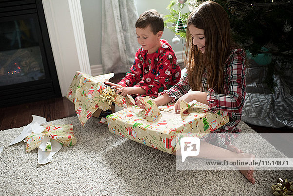 Bruder und Schwester öffnen Weihnachtsgeschenke