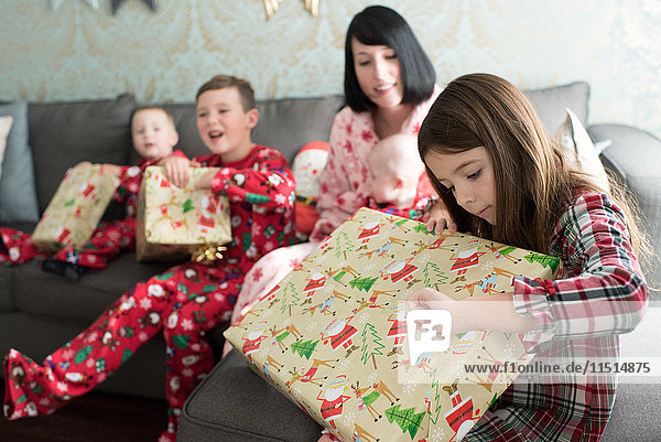 Mother and children opening christmas present