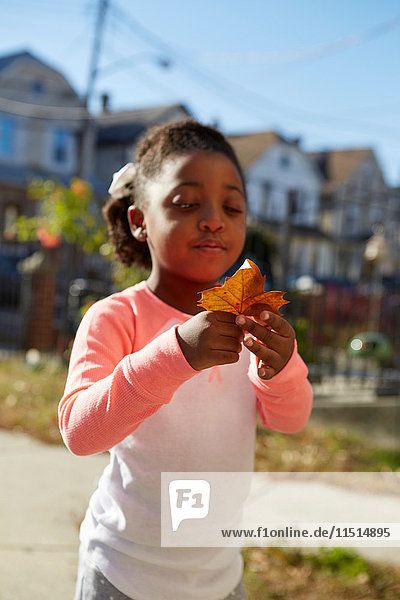 Young girl inspecting leaf