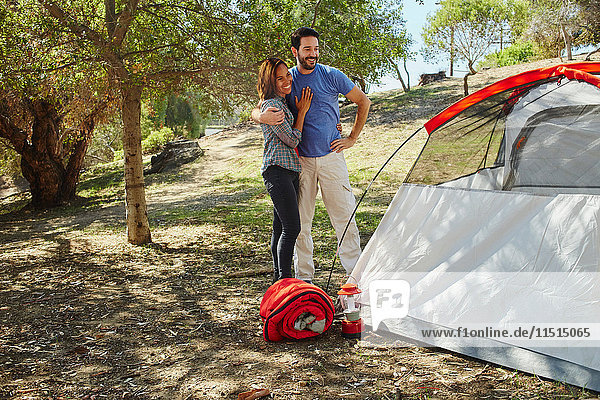 Mittelgroße erwachsene Paare zelten und bewundern ihr Zelt