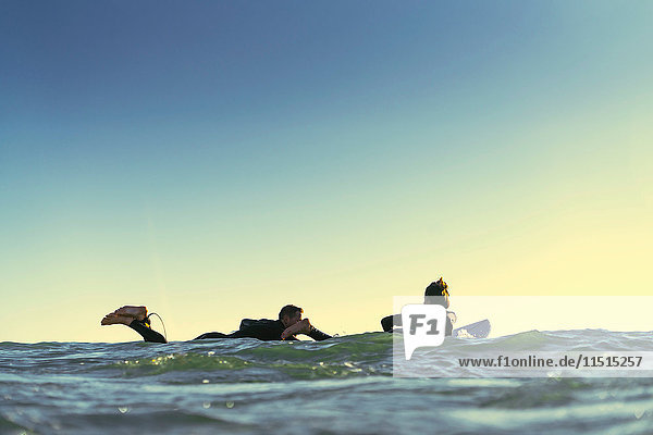 Surferpaar paddelt mit Surfbrettern auf See  Newport Beach  Kalifornien  USA