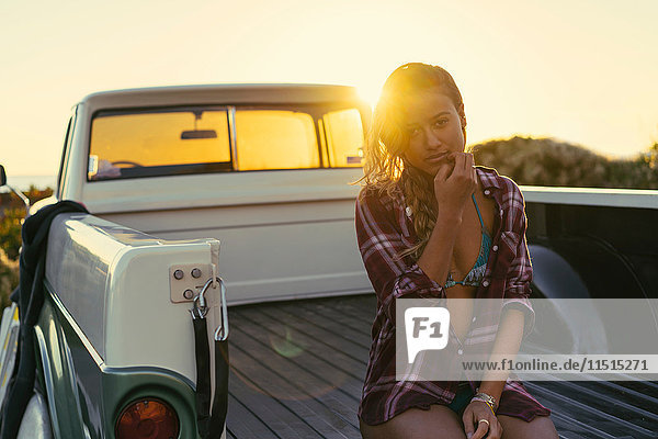 Portrait of young female surfer in back of pickup truck at Newport Beach  California  USA