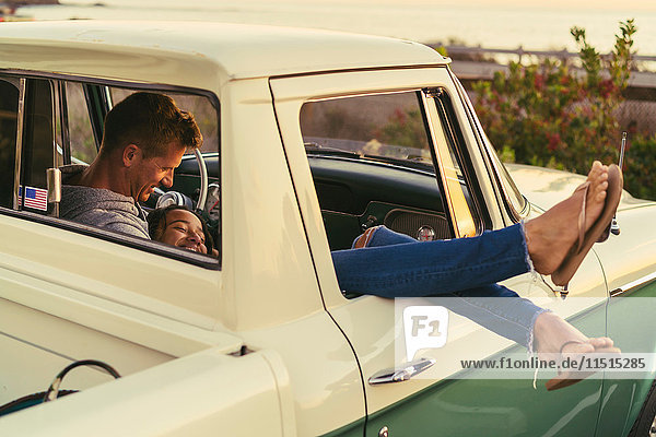 Romantic couple in pickup truck with legs out of window at Newport Beach  California  USA