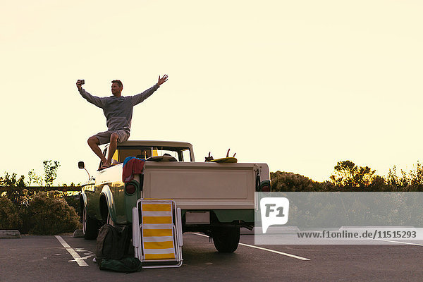Mann nimmt Smartphone-Selfie auf dem Rücksitz eines Pickup-Trucks in Newport Beach  Kalifornien  USA