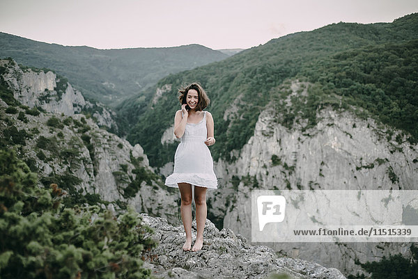 Lächelnde kaukasische Frau auf einem Berg stehend