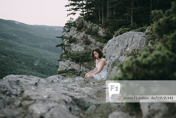 Traurige kaukasische Frau sitzt auf einem Berg