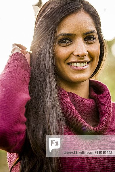 Porträt einer lächelnden indischen Frau mit Pullover