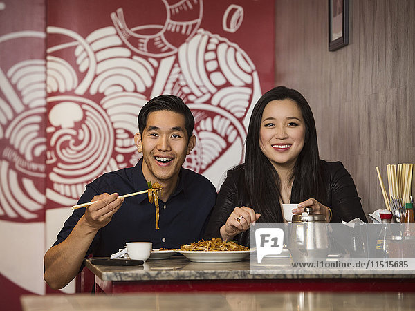 Lächelndes chinesisches Paar posiert im Restaurant