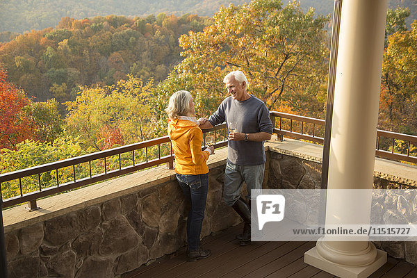 Older Caucasian couple enjoying wine and scenic view