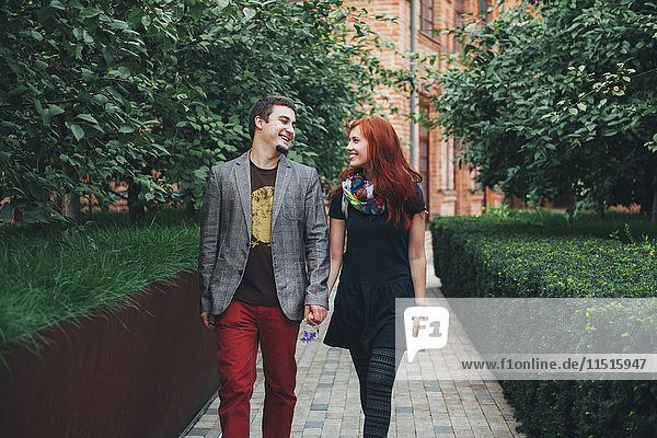 Lächelndes kaukasisches Paar beim Spaziergang in der Stadt