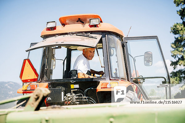Caucasian farmer driving tractor