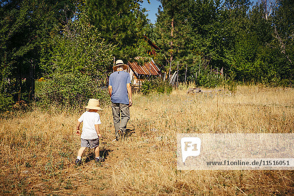 Kaukasischer Großvater und Enkel gehen im Feld spazieren