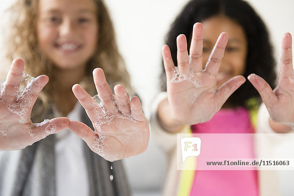 Mädchen zeigen Handflächen mit Seifenlauge