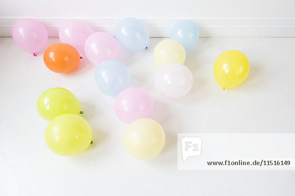 Mehrfarbige Luftballons auf weißem Boden