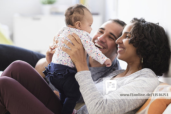 Hispanic mother and father playing with baby daughter