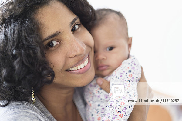 Hispanische Mutter posiert mit ihrer kleinen Tochter