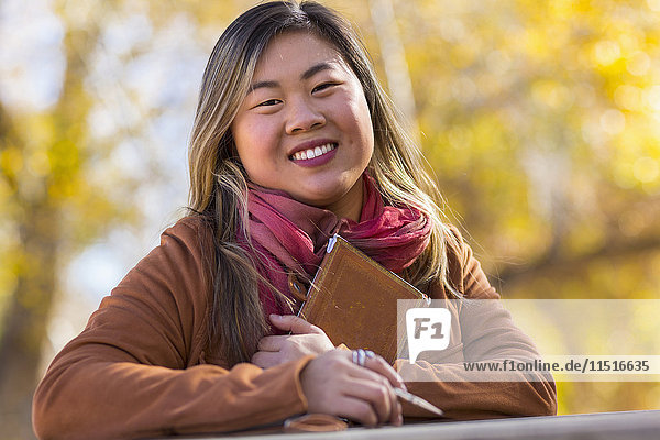Portrait of smiling Asian woman in autumn