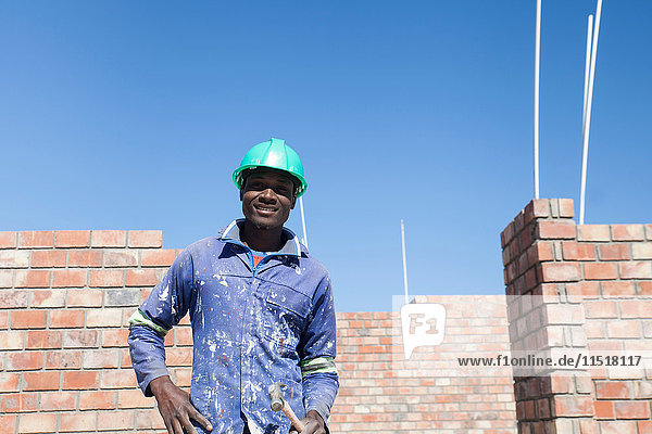 Portrait of builder wearing hard hat looking at camera smiling