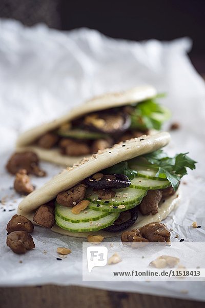 Vegane Bao-Tacos mit Sojastreifen  Gurke  Shiitake-Pilzen  gerösteten Erdnüssen und Sesam