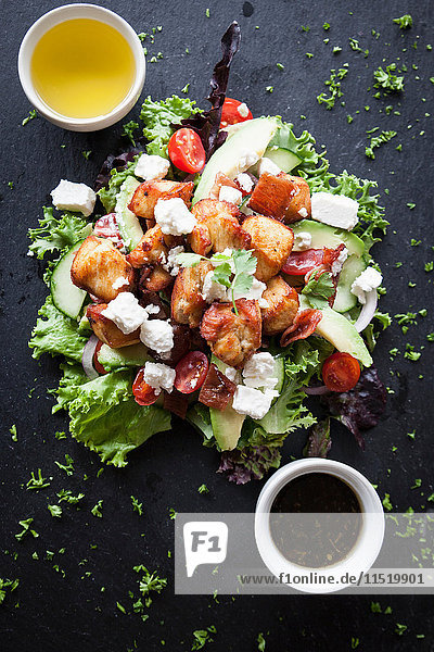Draufsicht auf Fleisch- und Feta-Salat mit Dip-Saucen auf Schiefer