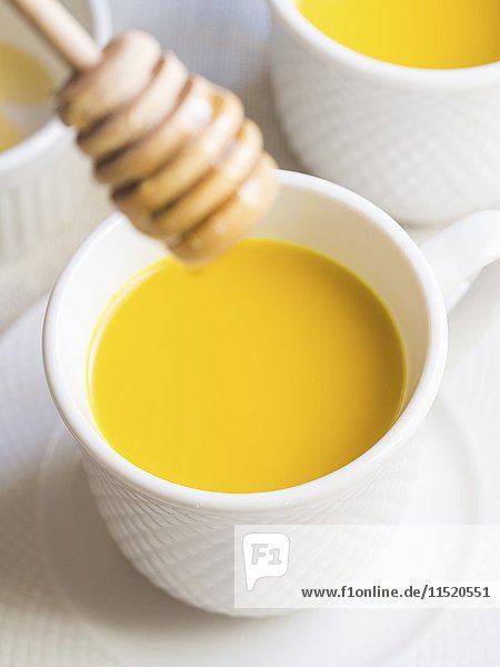 Homemade vegan golden milk with honey