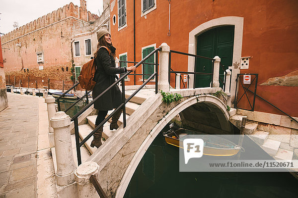 Woman crossing bridge over canal  Venice  Italy