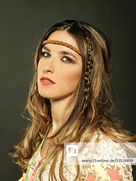 Studio portrait of beautiful young woman in bohemian fashion