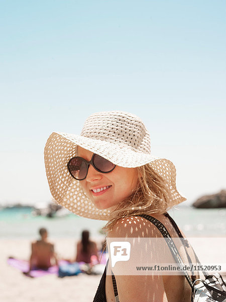 Porträt einer Frau mit Sonnenhut  die lächelnd in die Kamera schaut  Menorca  Spanien