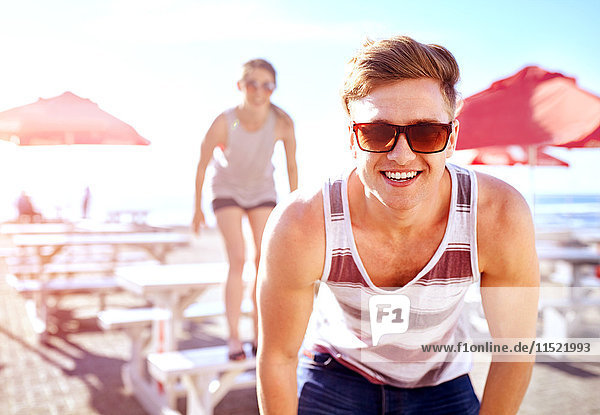 Porträt eines Mannes mit Sonnenbrille  der lächelnd in die Kamera schaut